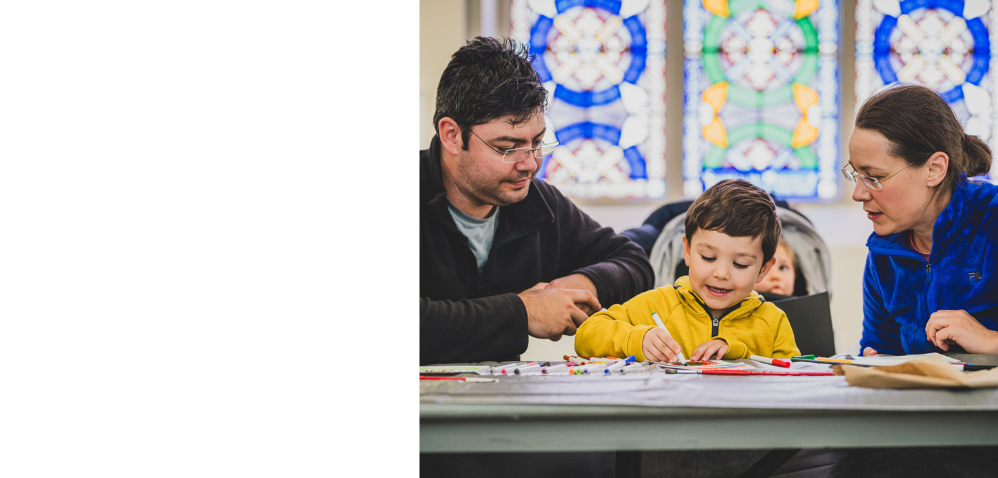 An child and two adults working on a drawing